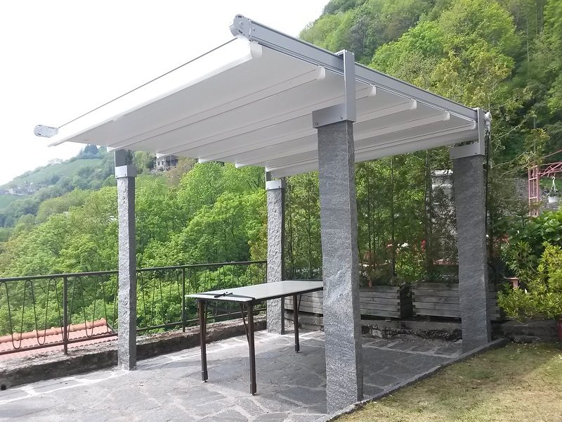 Pergola addossata con copertura in telo su un terrazzo affacciato sulle colline
