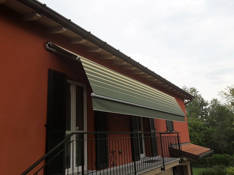 Tenda a caduta con tessuto a righe montata sul balcone di una villa